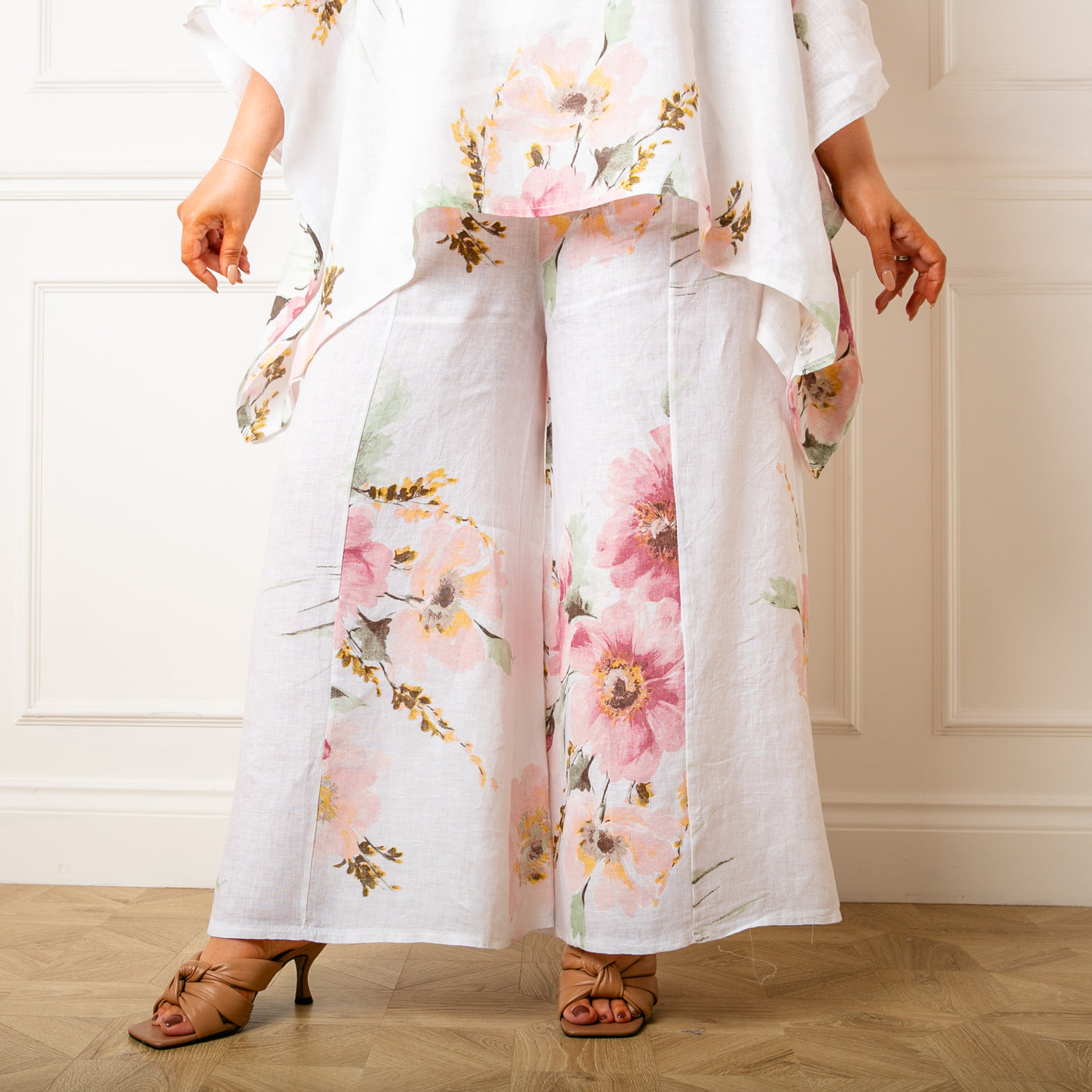 The white Bouquet Print Linen Trousers in a wide leg silhouette with pockets on either side