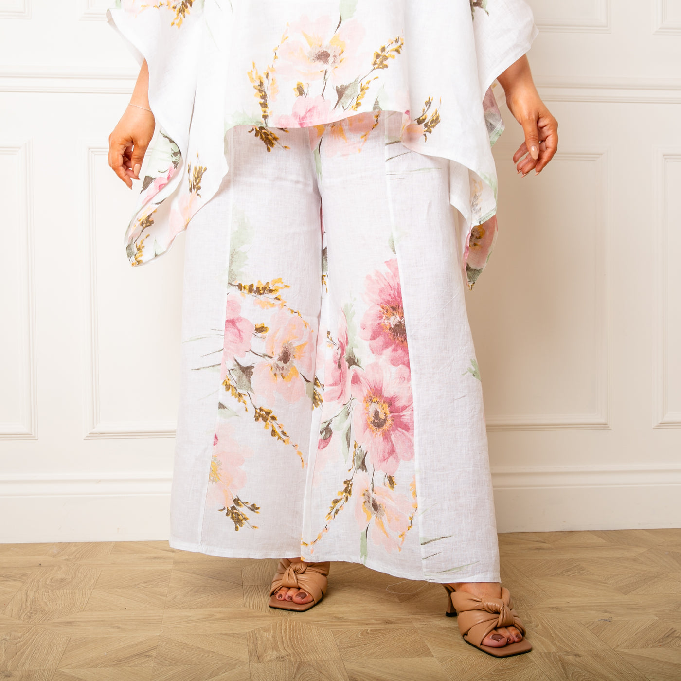 The white Bouquet Print Linen Trousers with a wide stretchy elasticated waistband for extra comfort 