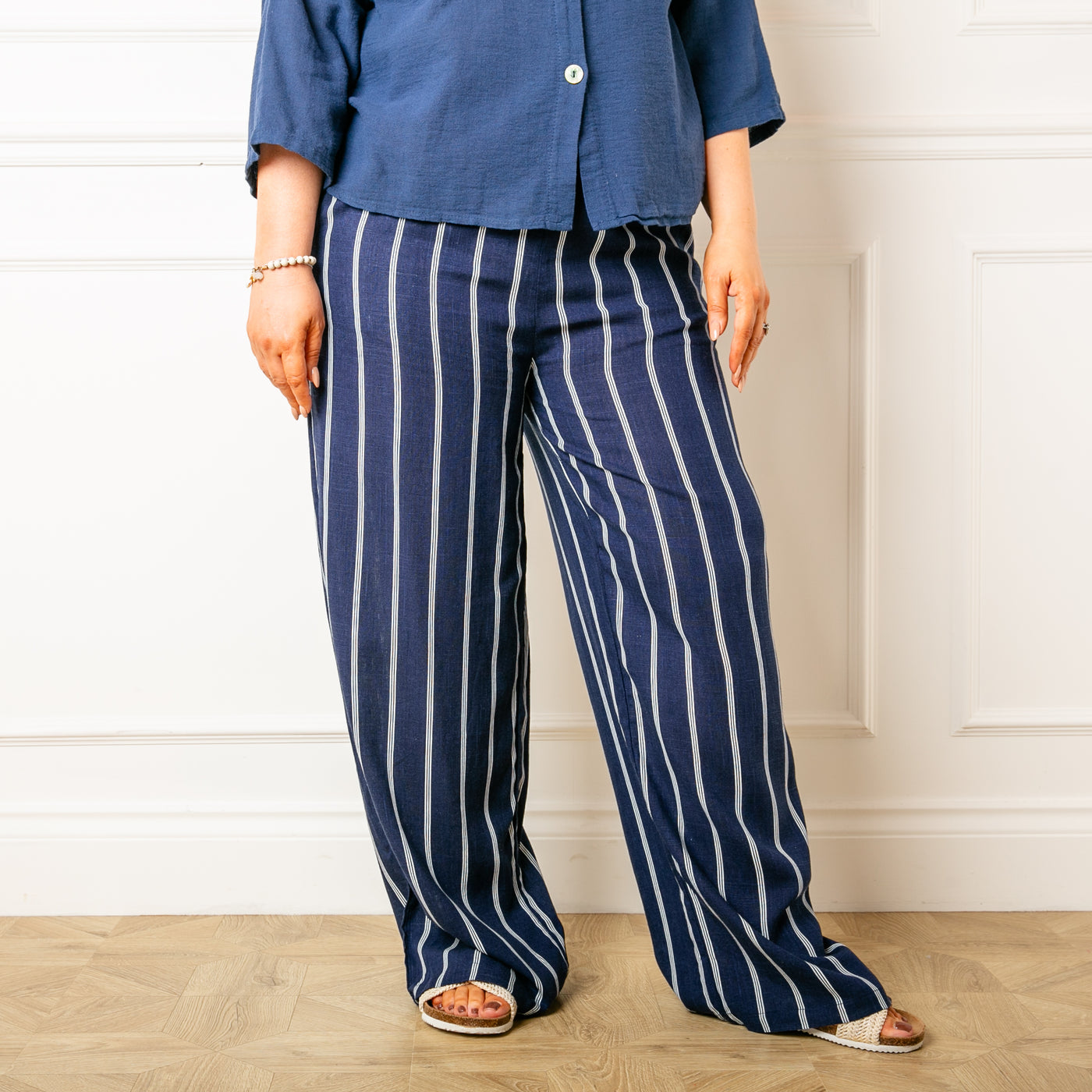 The navy blue Pinstripe Linen Trousers with side pockets and a wide leg silhouette 